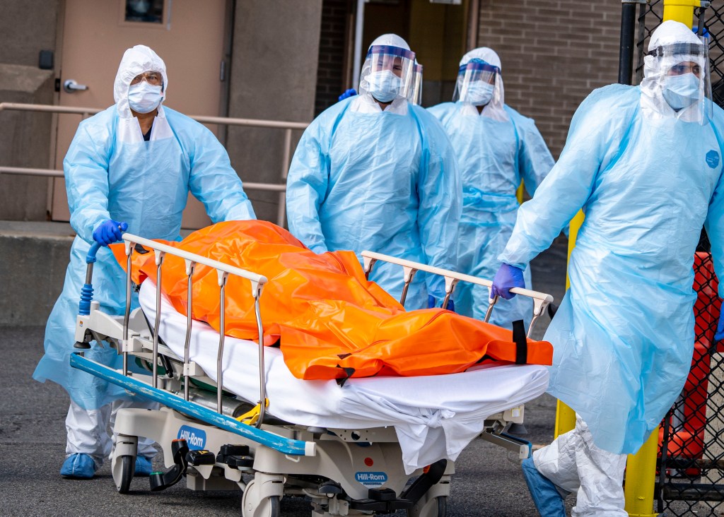 A grim scene at Wyckoff Heights Medical Center in Brooklyn, New York as a body in an orange bag is brought out to the refrigerated truck on April 2nd, 2020.