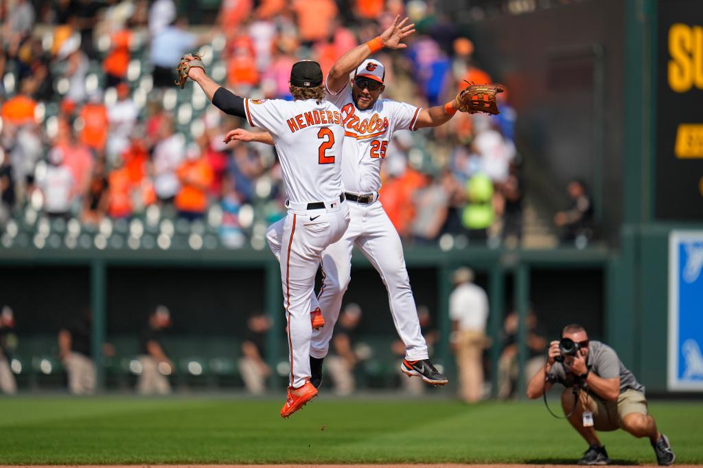 Baltimore Orioles shortstop Gunnar Henderson (2) and right fielder Anthony Santander (25) react.