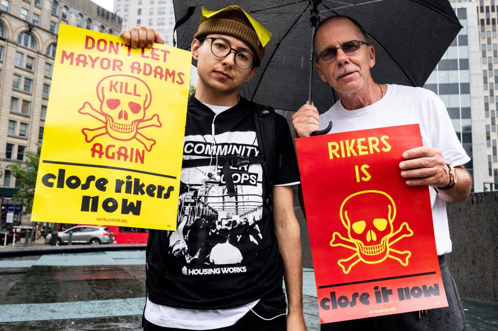 People holding placards saying "Don't let Mayor Adams kill again, close Rikers now"