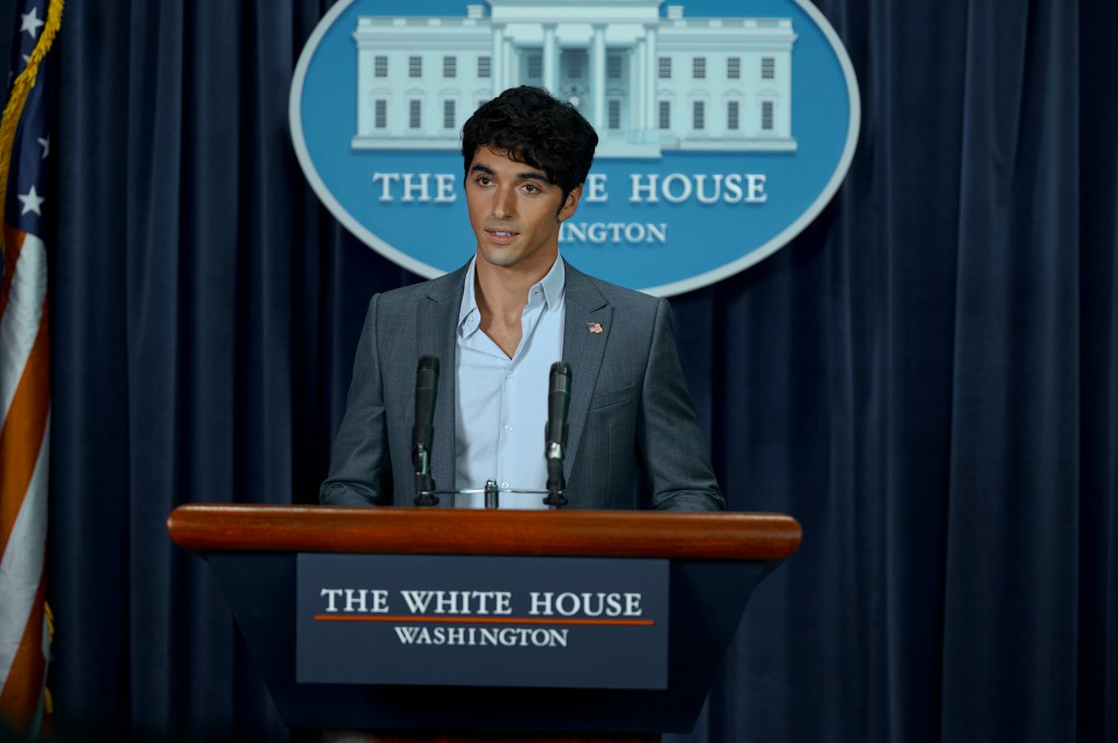 Alex (Taylor Zakhar Perez) gives a speech in "Red, White & Royal Blue" standing in front of the white house podium. 