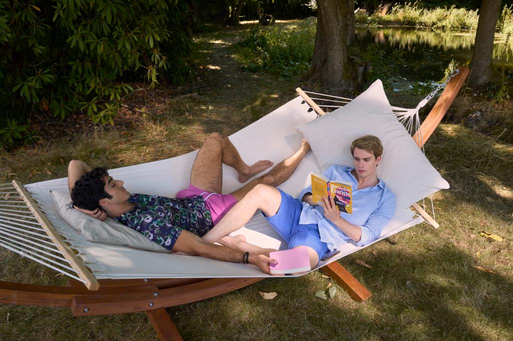 Nicholas Galitzine as Prince Henry and Taylor Zakhar Perez as Alex Claremont-Diaz  read books on a hammock together. 