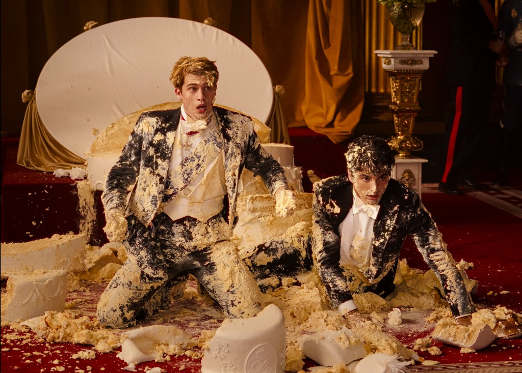 Henry (Nicholas Galitzine) and Alex (Taylor Zakhar Perez) kneeling on a floor covered in cake. 