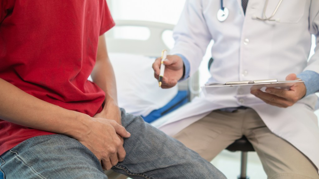 A man holding his crotch at the doctor's office. 