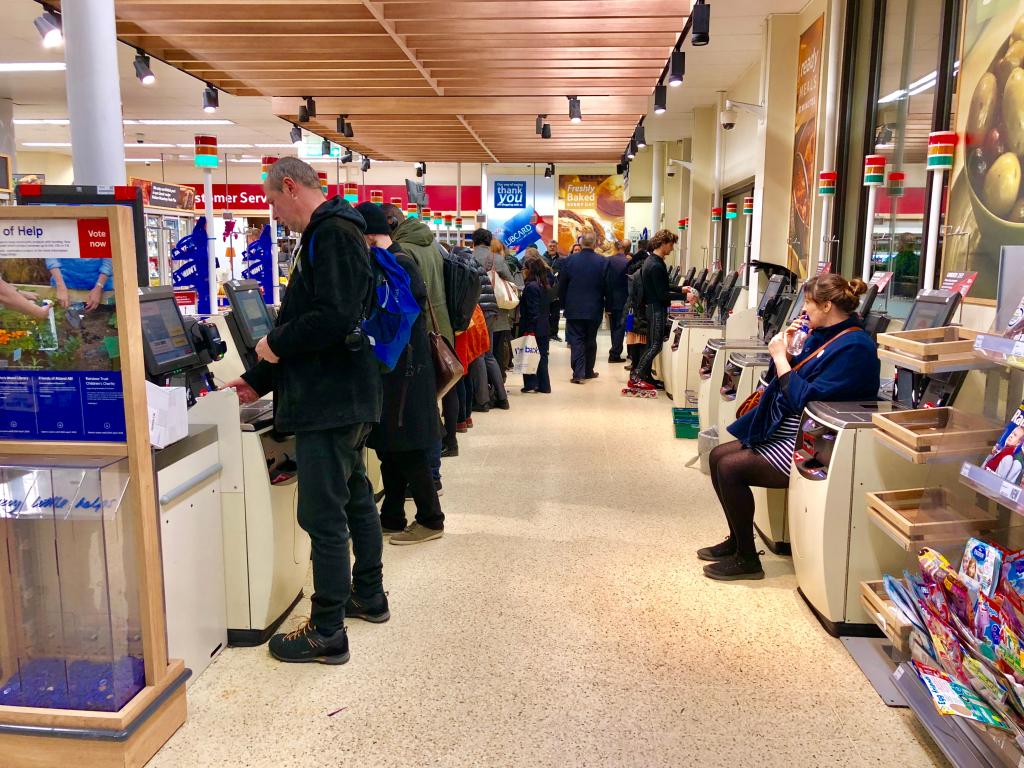 Customers use self service checkout machines to pay for groceries 