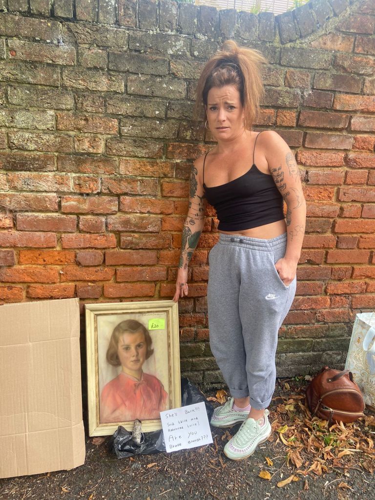 Photo of a woman next to a portrait. 