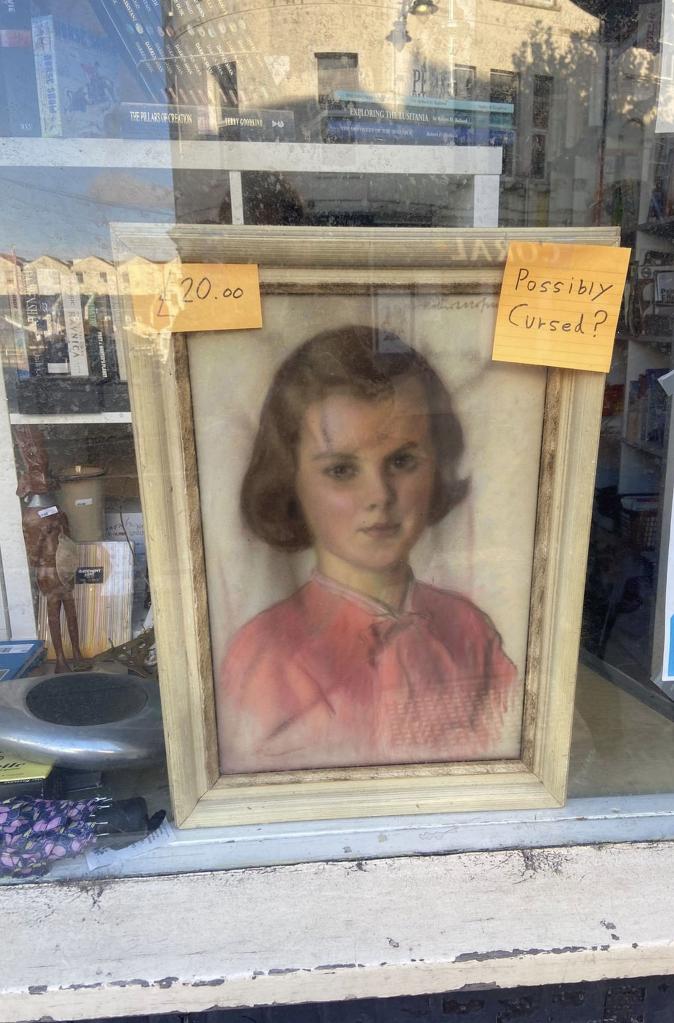 Photo of a painting hanging in a window. 