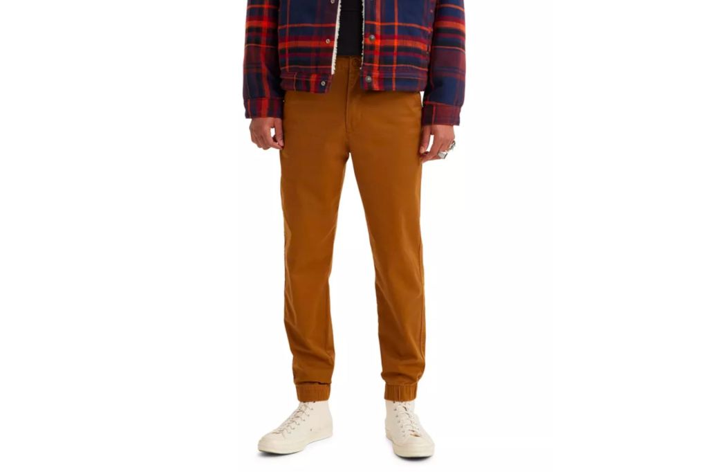 Man in plaid jacket, white sneakers, and brown joggers.