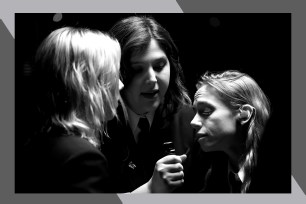 (L-R) Phoebe Bridgers, Lucy Dacus and Julien Baker of Boygenius sing together on the same microphone.