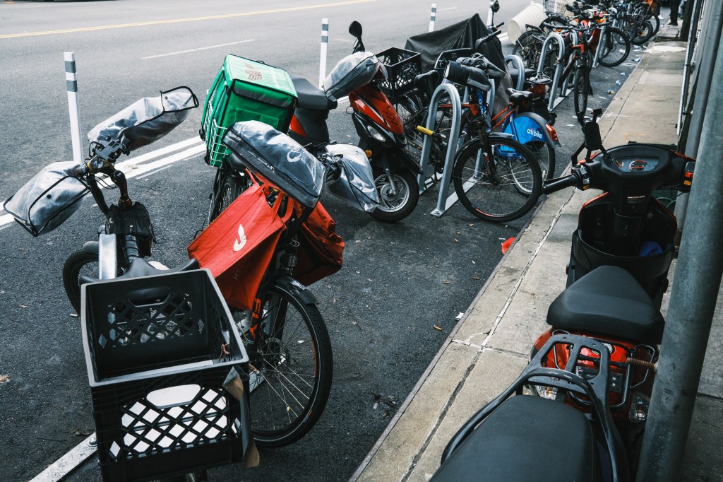 A cluster of bikes parked on the curb.