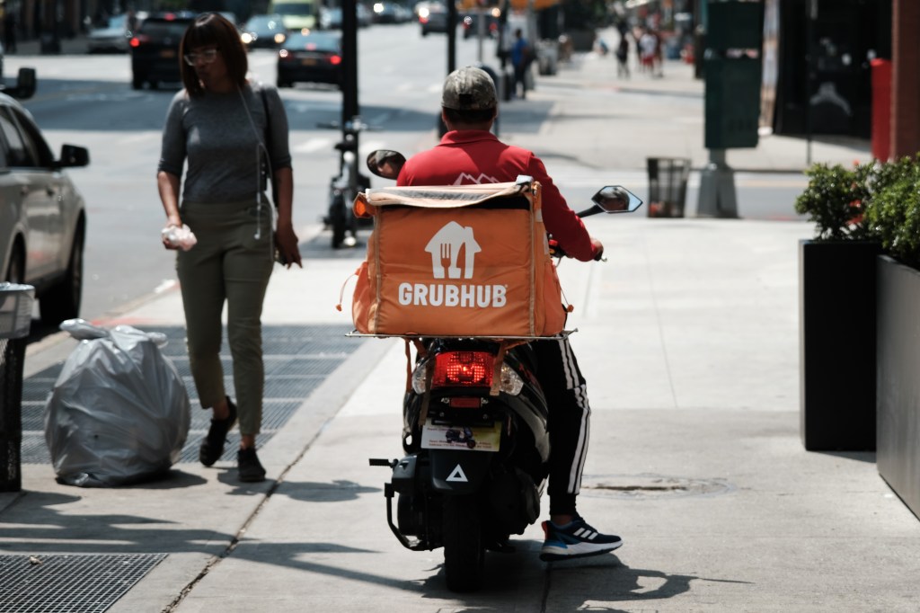 A delivery worker with a GrubHub back pack.