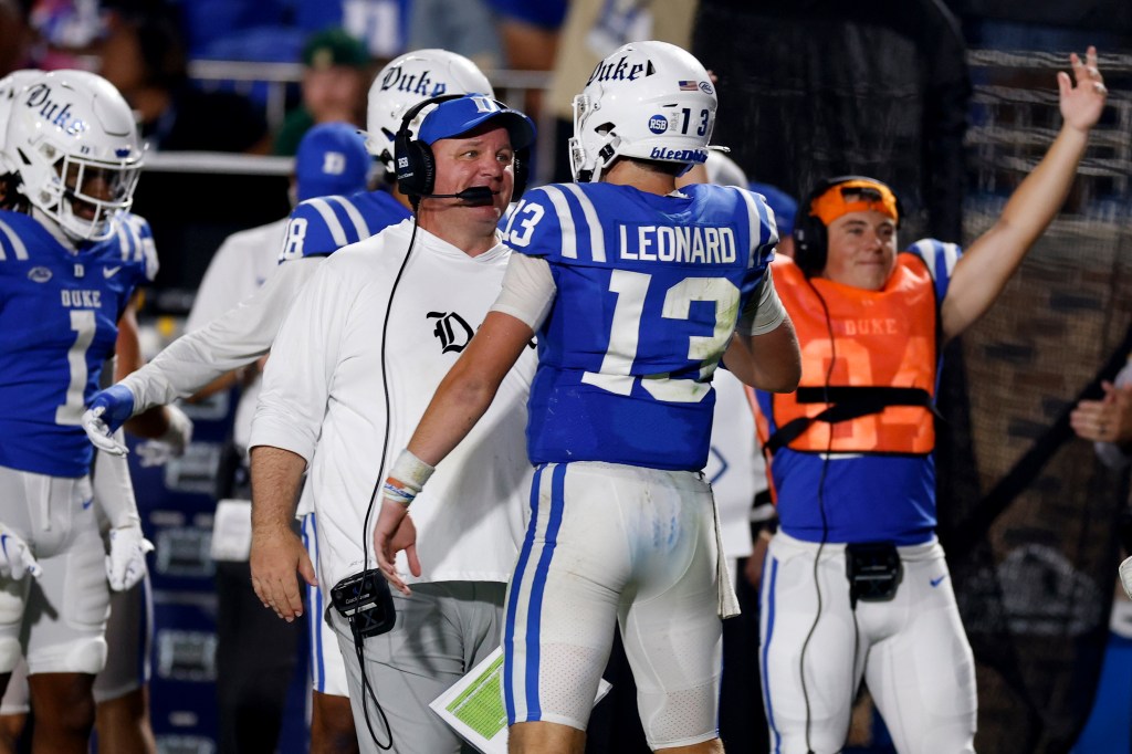 Duke head coach Mike Elko talks to quarterback Riley Leonard.