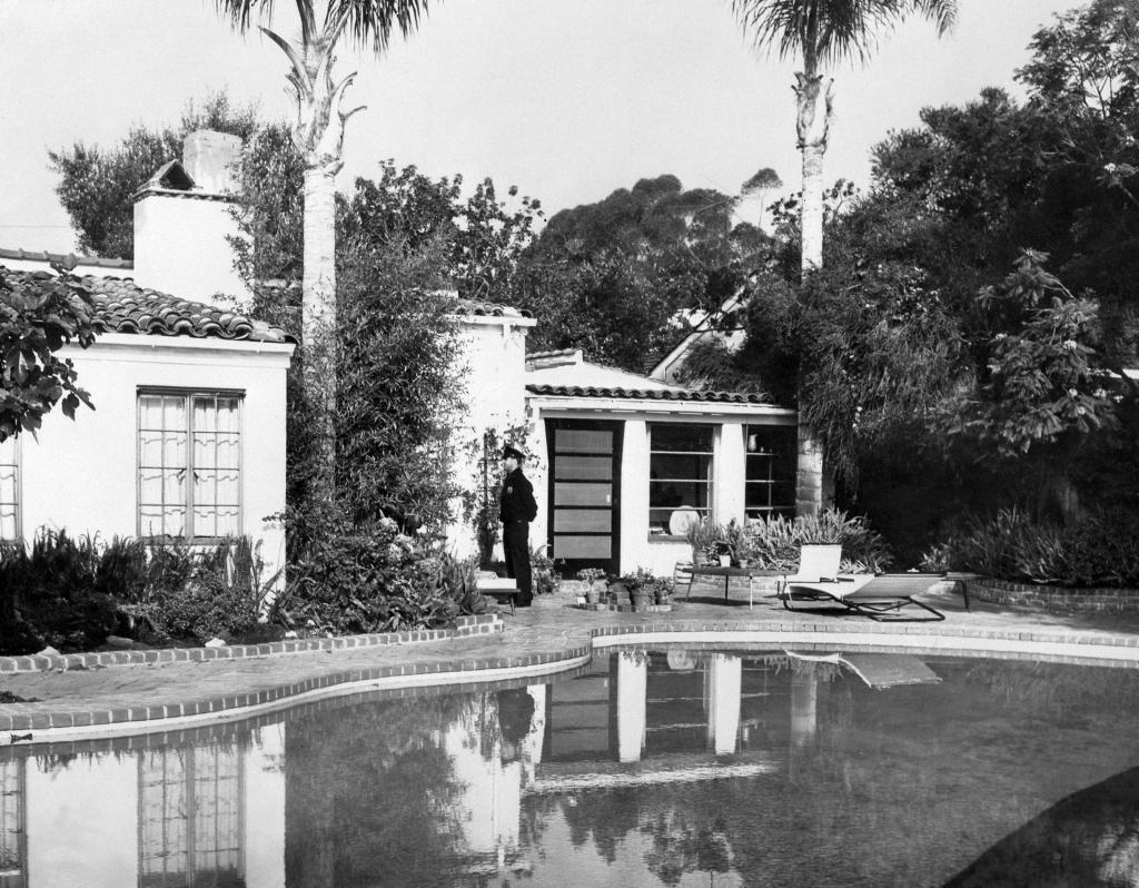 A policeman stands in front of american actress Marilyn Monroe's house, where she was discovered dead,