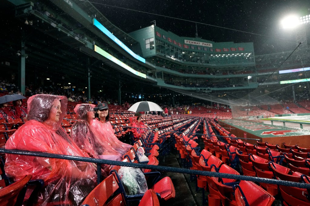 Baseball fans wear ponchos in the stands during a rain delay before a scheduled baseball game between the New York Yankees and the Boston Red Sox