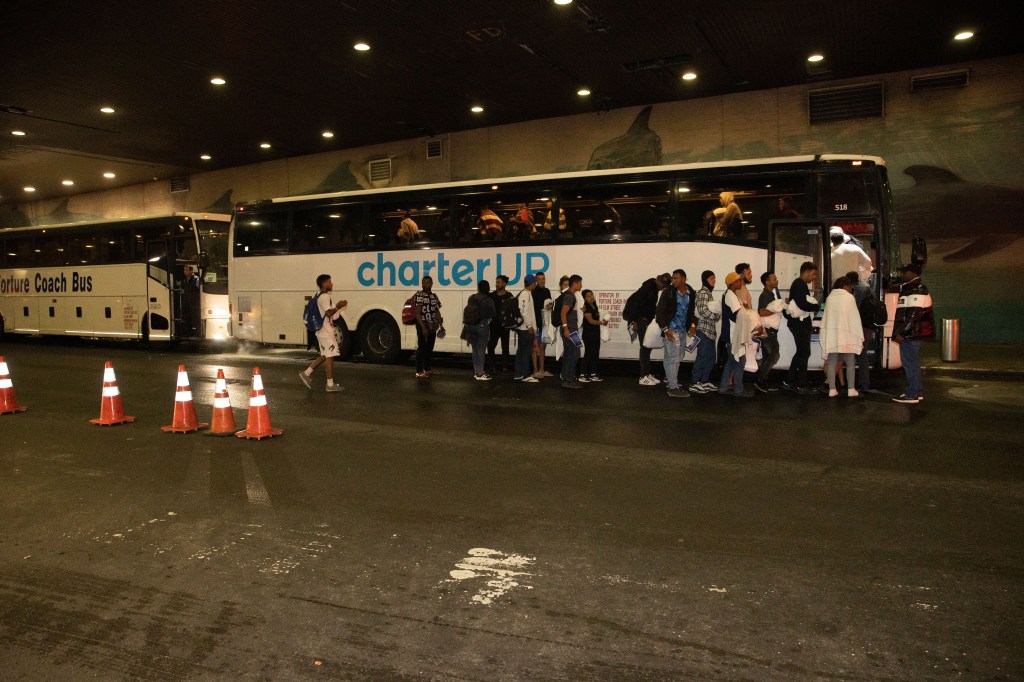 Migrants are seen going to busses that were taking them to the Roosevelt Hotel 