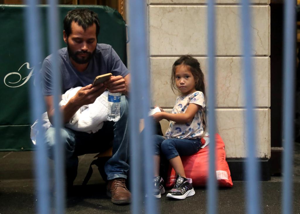 Migrant family awaits entry into the Roosevelt Hotel on Monday morning.