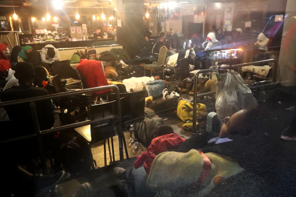 Migrants sleeping on floor of Roosevelt Hotel bar