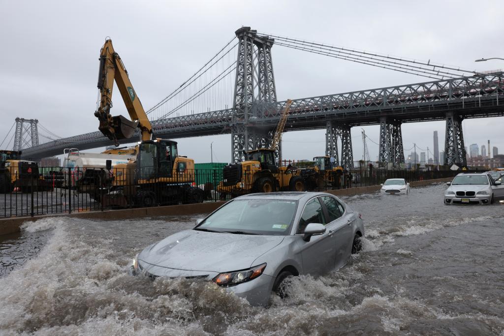 A motorist drives through a flooded FDR Drive in Manhattan near the Williamsburg Bridge.