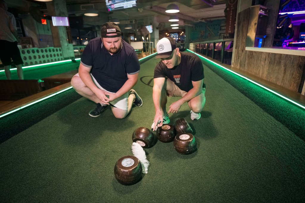 Reporter Alex Mitchell scores his first ever feather bowling point by landing closest to the pin.