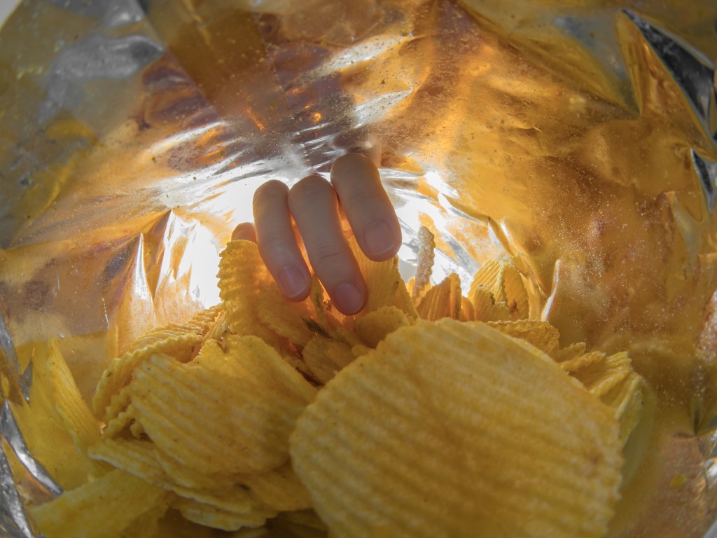Taking snack chips inside package.