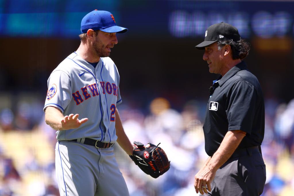 Max Scherzer #21 of the New York Mets argues with umpire Phil Cuzzi #10 during the third inning against the Los Angeles Dodgers at Dodger Stadium on April 19, 2023 in Los Angeles, California. 