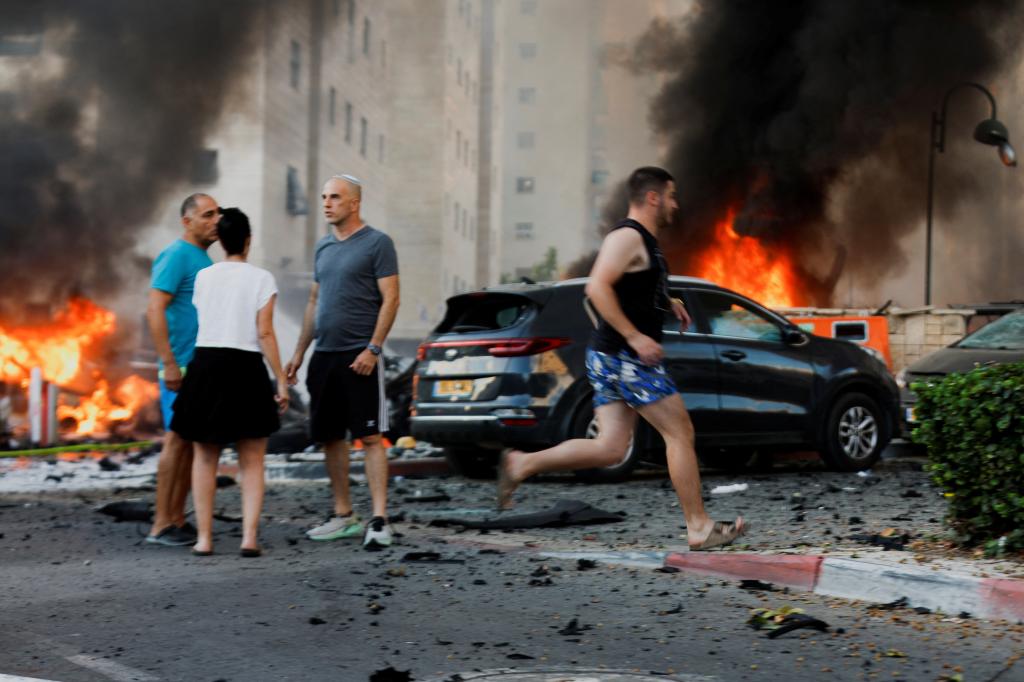 People react on the road, in the aftermath of rocket barrages that were launched from Gaza, in Ashkelon, Israel October 7, 2023.