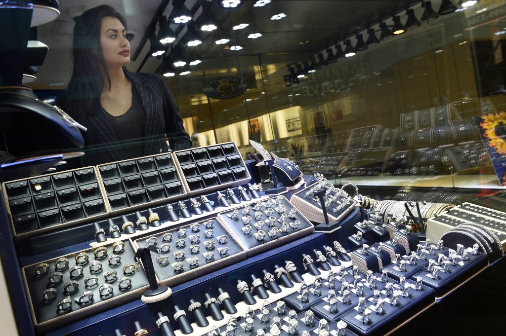 Jewelry store on West 47th street with woman appearing behind a glass case of diamond rings