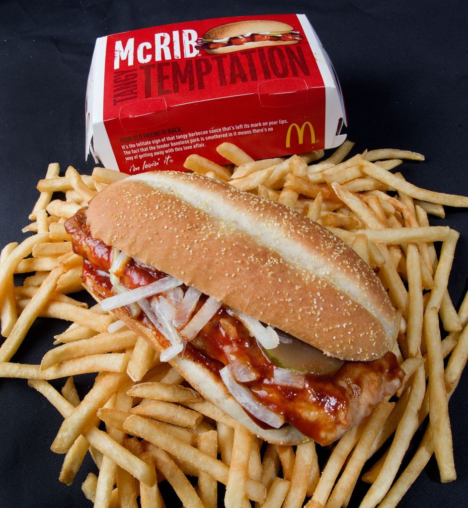 Photo of a McRib with french fries. 