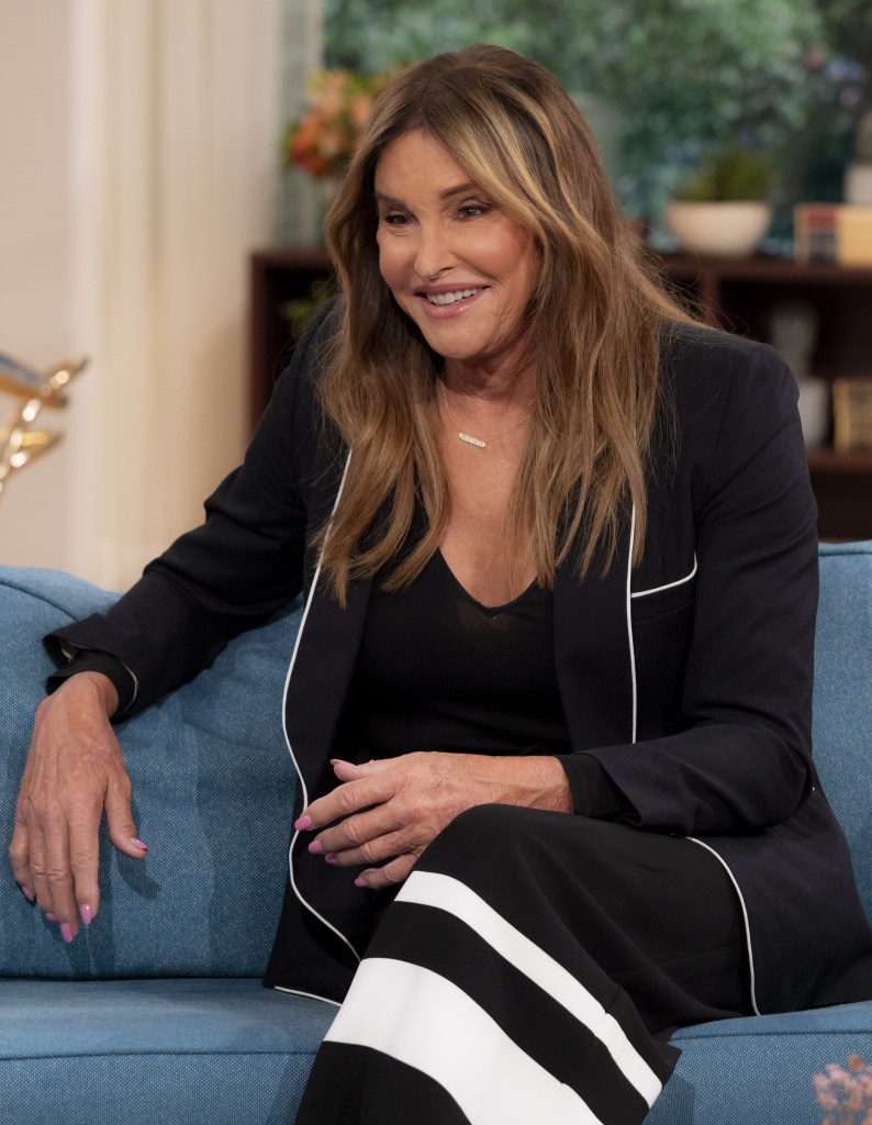 Caitlyn Jenner smiling on a couch. 
