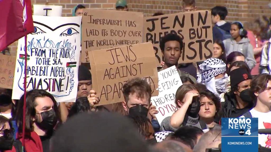 Students are pictured at the rally holding signs, including one reading "Jews against apartheid."