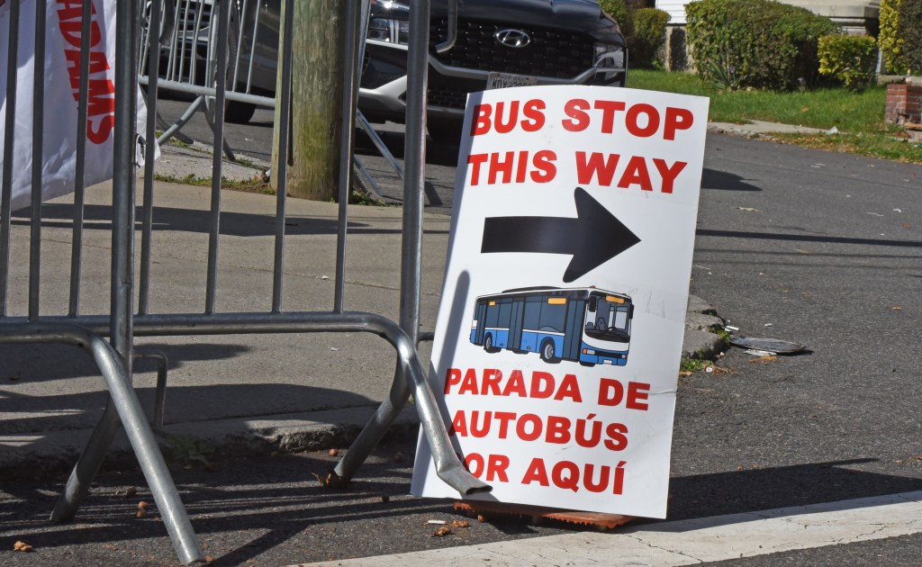 A  sign directing the migrants to the bus seen on the street. 