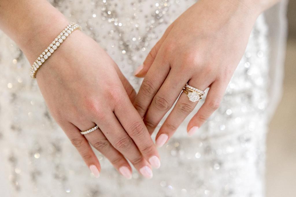 Photo from Ada Diamonds of woman's engagement rings against her dress