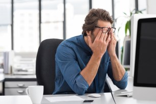 Portrait of an upset businessman at desk in office.