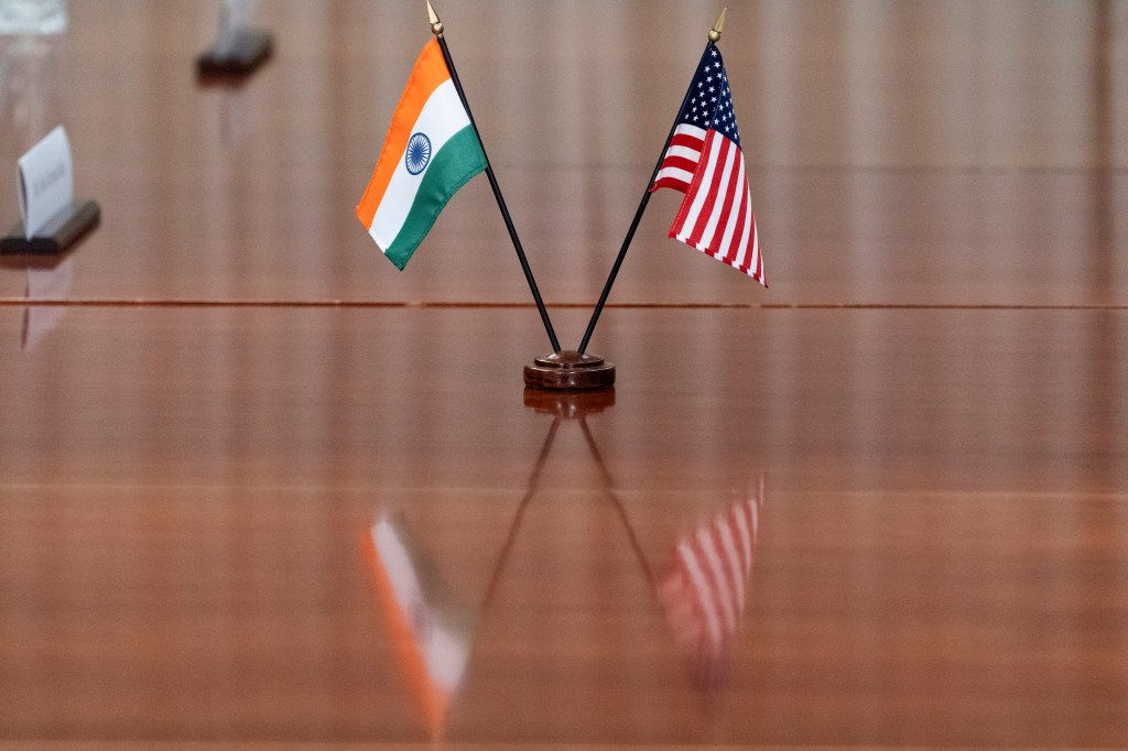 India and US flags on a wooden desk