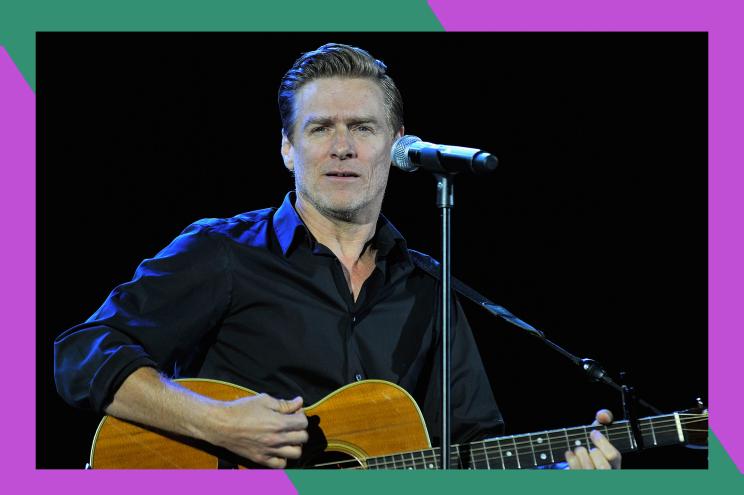 Bryan Adams plays the guitar onstage.