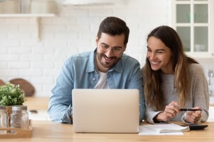 A couple researches how to upgrade their savings account.