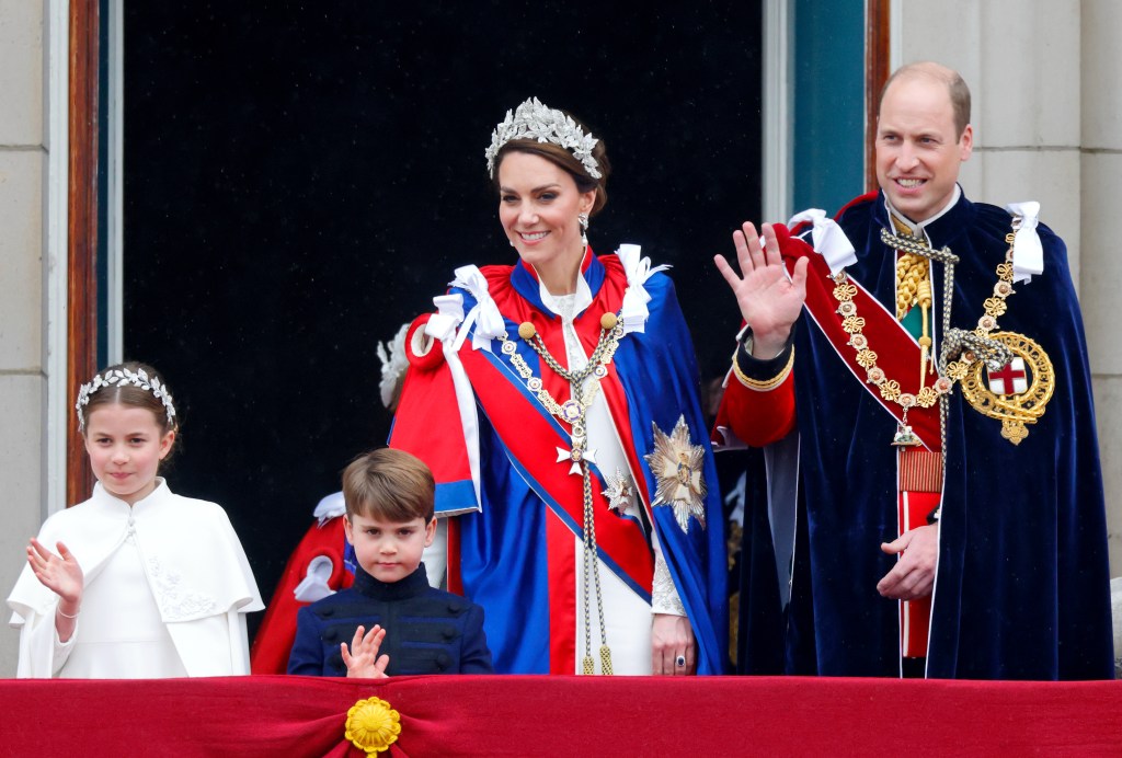 Princess Charlotte of Wales, Prince Louis of Wales, Catherine, Princess of Wales and Prince William, Prince of Wales watch an RAF flypast from the balcony of Buckingham Palace following the Coronation of King Charles III.