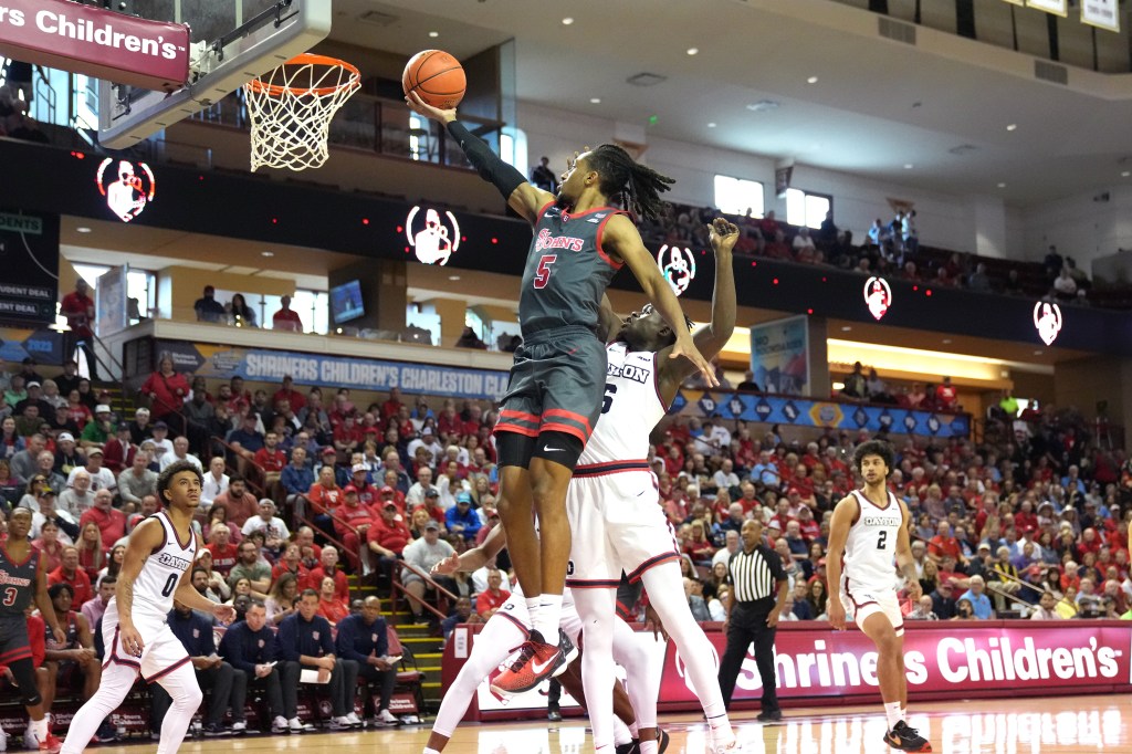 Daniss Jenkins #5 of the St. John's Red Storm drives to the basket by Enoch Cheeks #6 of the Dayton Flyers