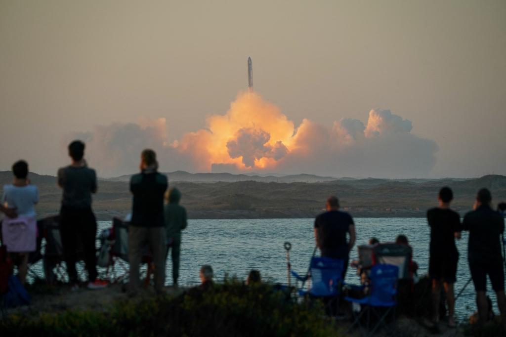 People watch as SpaceX's next-generation Starship spacecraft atop its powerful Super Heavy rocket lifts off.
