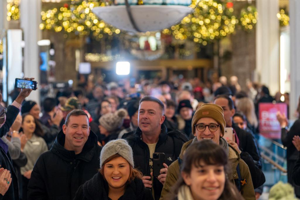 Holiday shoppers walking through a decorated store.