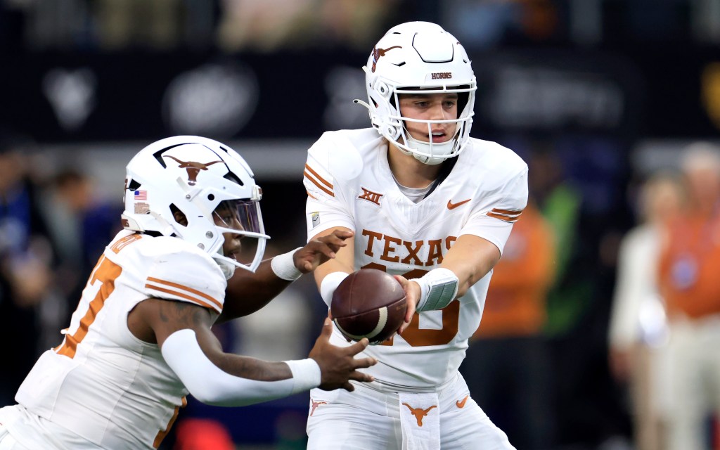 Arch Manning #16 of the Texas Longhorns hands off to teammate and running back Savion Red #17 against the Oklahoma State Cowboys in the second half of the Big 12  Championship.