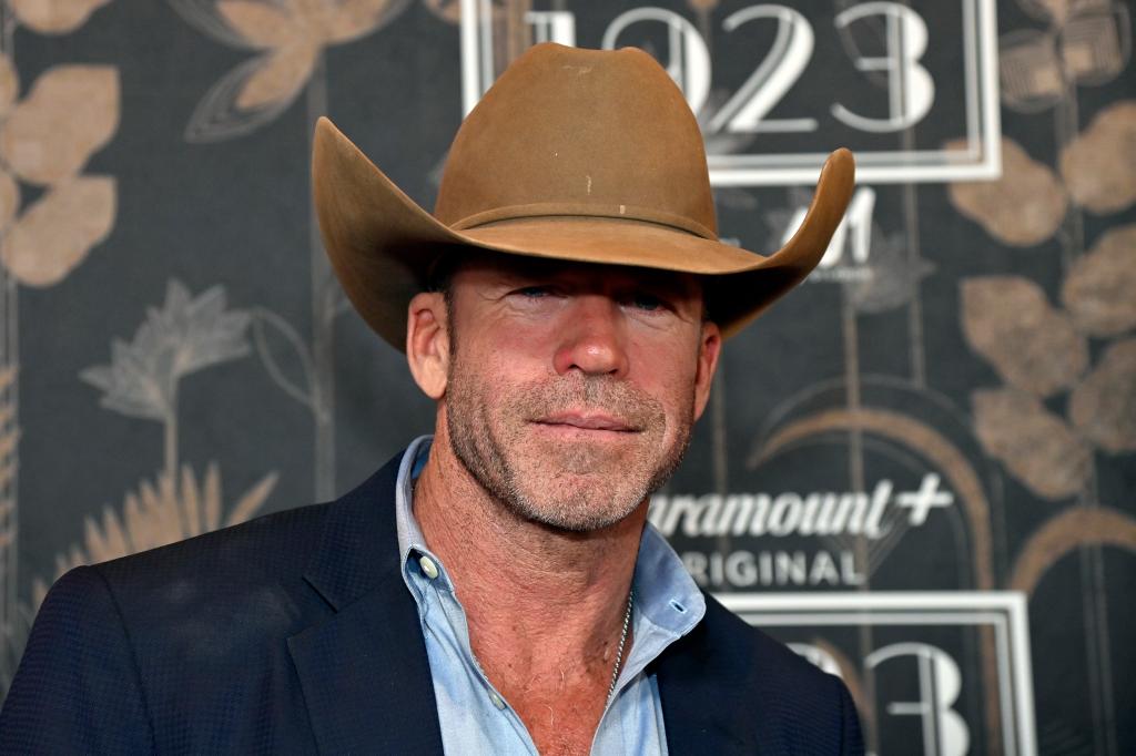 Taylor Sheridan smiling in a cowboy hat. 