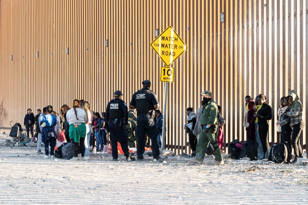 Migrants wait to be transported by the U.S. border patrol after crossing the border wall into the U.S. from Mexico, as the number of migrants surges in the border town of Lukeville, Arizona, U.S. December 14, 2023. 