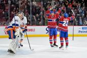 Montreal Canadiens forward Cole Caufield (22) celebrates with teammate forward Nick Suzuki (14) after scoring a goal against New York Islanders goalie Semyon Varlamov.