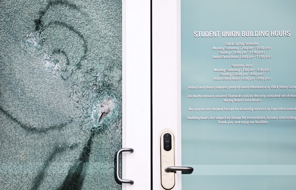  A shattered door is viewed at the student union building the morning after a shooting left three dead at the University of Nevada.