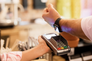 A man uses his apple watch to pay his bill.