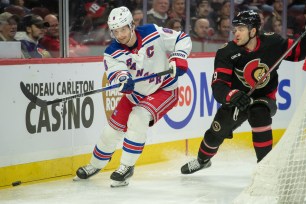 Jacob Trouba moves the puck away from Josh Norris during the Rangers' loss to the Senators.