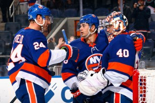 Scott Mayfield (left) and Alexander Romanov celebrate with goalie Ilya Sorokin after the Islanders' 7-3 blowout win over the Blue Jackets.