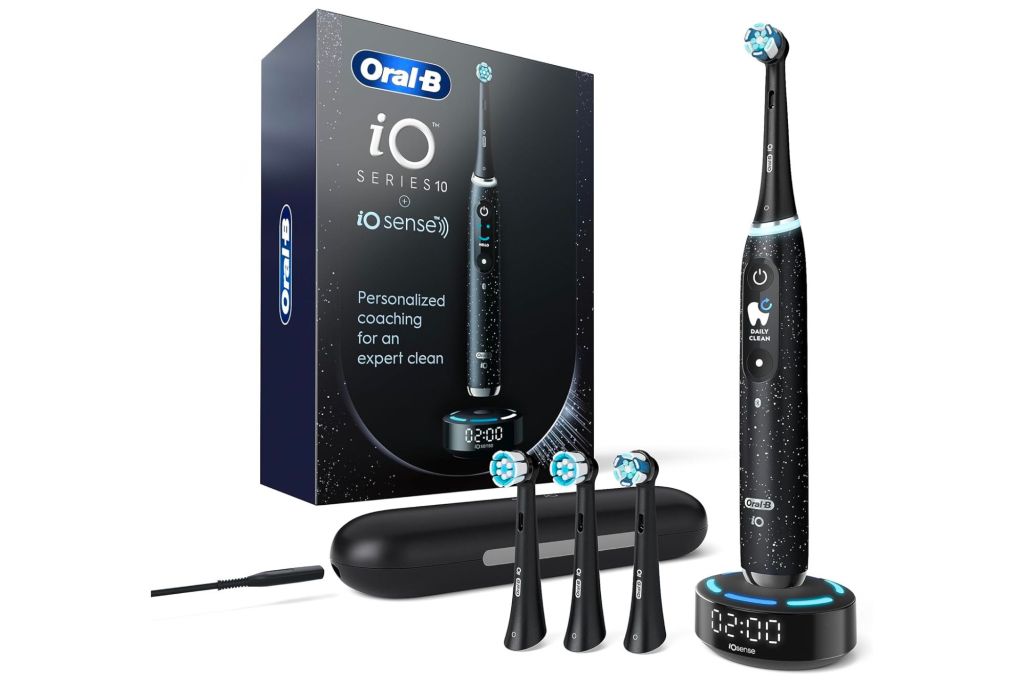 An electric toothbrush on a base, different brush heads and box.