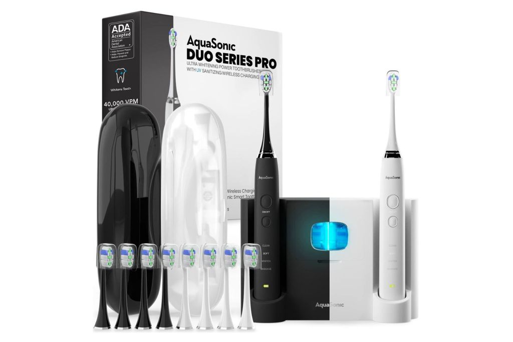 A dual electric toothbrush set with a UV charging station.