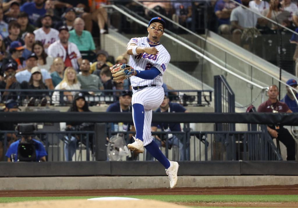 Mets third baseman Mark Vientos (27) is late on a throw allowing Atlanta Braves right fielder Ronald Acuna Jr. (13) to reach first base